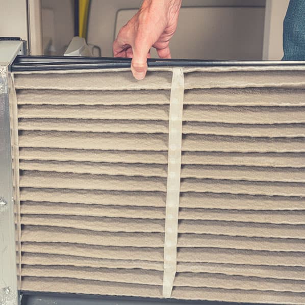 Man changes filter on home HVAC unit